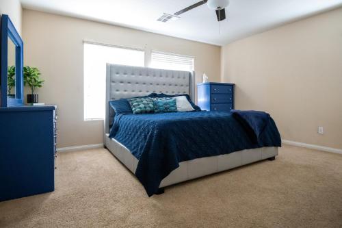 a bedroom with a bed with a blue comforter and a window at Large 3BR King Suite Moments Away From Strip in Las Vegas