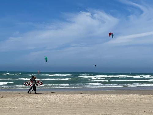 a man walking on the beach with a surfboard at Løkke-bo in Løkken