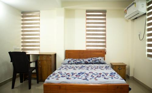 a bedroom with a bed and a table and chairs at Salalah Enclave - 3 AC Bedroom House at Vytilla, Kochi in Cochin