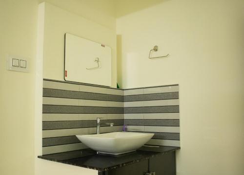 a bathroom with a sink and a mirror at Salalah Enclave - 3 AC Bedroom House at Vytilla, Kochi in Cochin