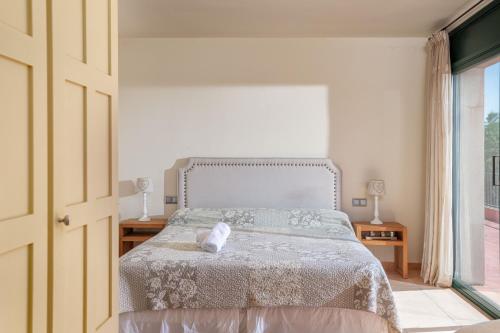 a bedroom with a bed and a large window at Flateli Peralada in Peralada