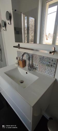 um lavatório branco na casa de banho com um espelho em Tendance et Charmant F2 em Le Havre