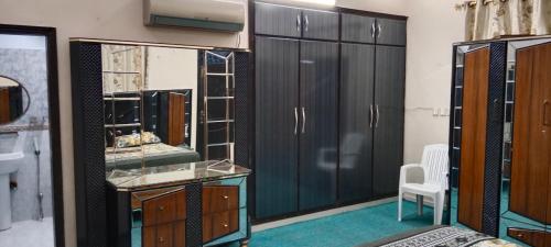 ein Ankleidezimmer mit schwarzen Schränken und einem Spiegel in der Unterkunft Saadi Guest House in Karatschi