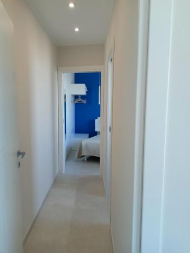 a hallway leading to a bedroom with a blue wall at Casa Mylai in Castelmola