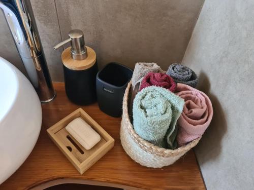 una cesta de toallas sentada en un mostrador junto a un fregadero en Fay's luxury loft, en Volos