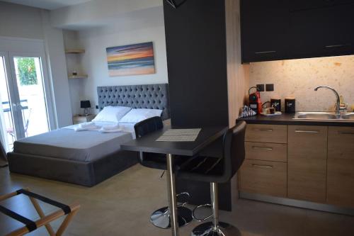 1 dormitorio con 1 cama y cocina con escritorio en Fay's luxury loft, en Volos