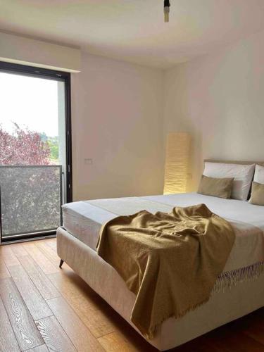 a bedroom with a large bed with a large window at Casa Capelute in Udine