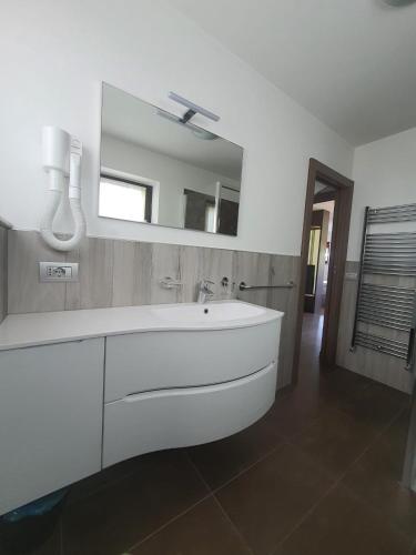 a bathroom with a white sink and a mirror at VERDELAGO Appartamenti in Livigno