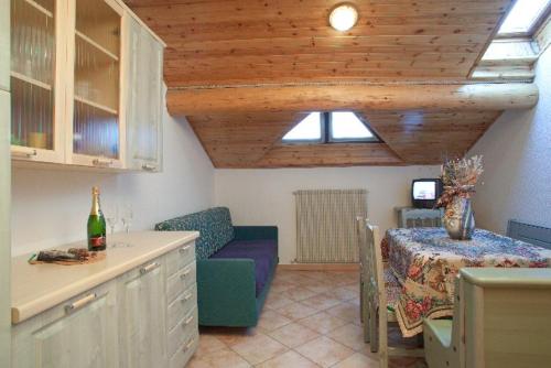 uma sala de estar com um sofá e uma mesa com uma garrafa de vinho em VERDELAGO Appartamenti e CASA CRY em Livigno