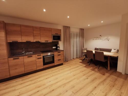 a kitchen with wooden cabinets and a dining room at Feine Bleibe in Eben im Pongau