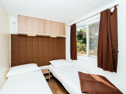 - 2 lits dans une chambre avec fenêtre dans l'établissement Mobile Homes Zaton Holiday Resort Zaton-Nin - CDN02045-MYC, à Zaton