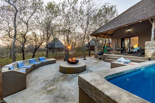 a backyard with a swimming pool and a fire pit at Blue Goose Bush Retreat in Marloth Park