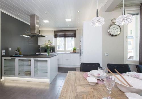 een keuken en eetkamer met een tafel en een klok bij Tasokas ok-talo luonnon äärellä lähellä kaupunkia in Seinäjoki
