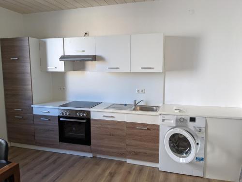 a kitchen with a washing machine and a washer at Monteurunterkunft Weiden by HausGruenerBaum in Weiden