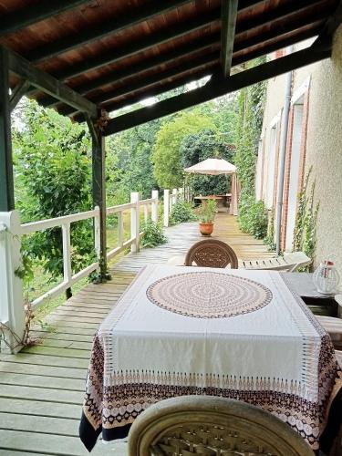 una mesa en un porche con un mantel blanco en Domaine de Frély, en Pouzauges