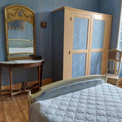 1 dormitorio con espejo grande y cama en Domaine de Frély, en Pouzauges
