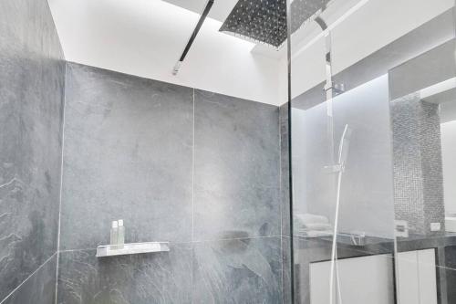 ein Bad mit einer Dusche und einer Glastür in der Unterkunft Luxury modern two bedroom duplex by Roland Garros in Paris