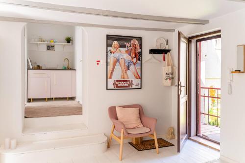 een woonkamer met een stoel en een foto aan de muur bij Tomte - scandinavian apartment in Krakau