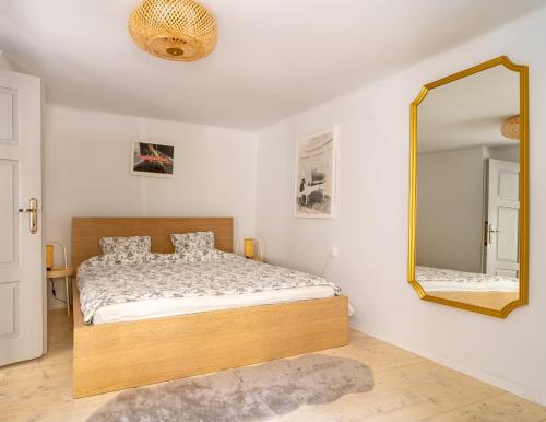 een slaapkamer met een bed en een spiegel bij Tomte - scandinavian apartment in Krakau