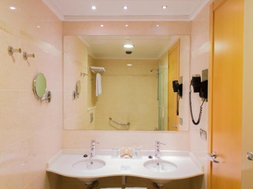 baño con lavabo y espejo grande en AR Diamante Beach & SPA Hotel 4 SUP, en Calpe