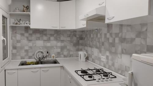 uma cozinha branca com um fogão e um lavatório em Metro La Salut em Badalona