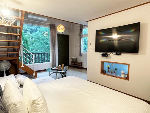 橫山鄉的住宿－登美山莊，卧室配有一张床,墙上配有电视。