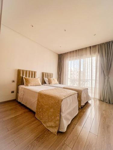 a bedroom with two beds and a large window at Pristigia rabat in Rabat