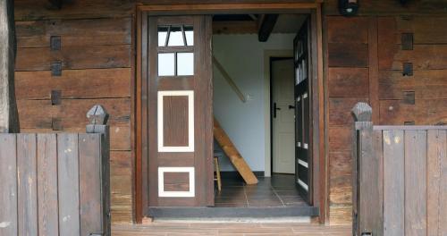 an open door of a wooden house with a wooden fence at Tradicionalna zagorska drvena kuća Stara murva in Tuheljske Toplice