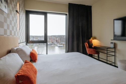 a hotel room with a large bed and a window at Mercure Namur Hotel in Namur