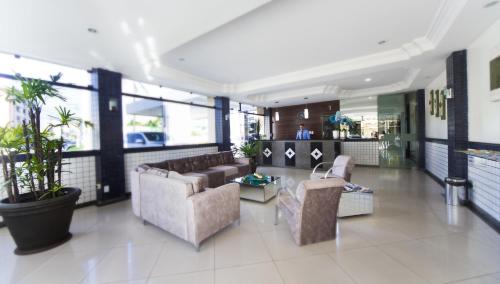a lobby with couches and chairs in a building at Hotel Rekinte in Aracaju