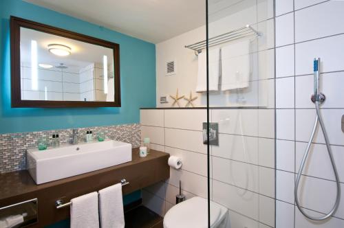 y baño con lavabo, aseo y espejo. en Herods Dead Sea – A Premium Collection by Fattal Hotels en Ein Bokek