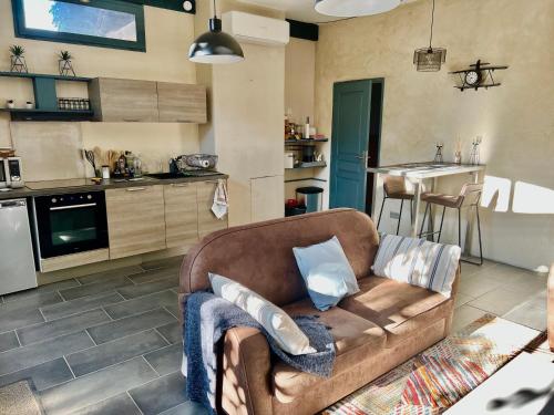 un salon avec un canapé et une cuisine dans l'établissement Domaine Feuillet, à Chanas