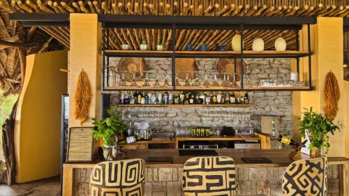 un restaurante con un bar con una pared de piedra en Soroi Lions Bluff Lodge 