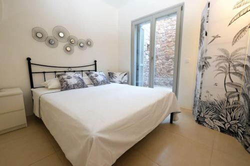 Un dormitorio con una gran cama blanca y una ventana en Miss Valentina-Modern Stone Villa in Aegina en Aegina Town