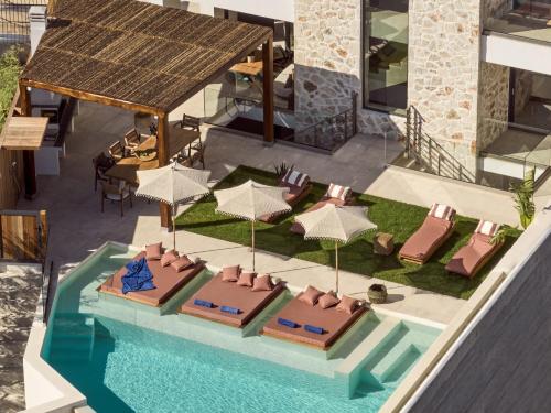 an overhead view of a pool with chairs and umbrellas at Ismet Villa, a SeaView Glorious Hideaway, By ThinkVilla in Akrotiri