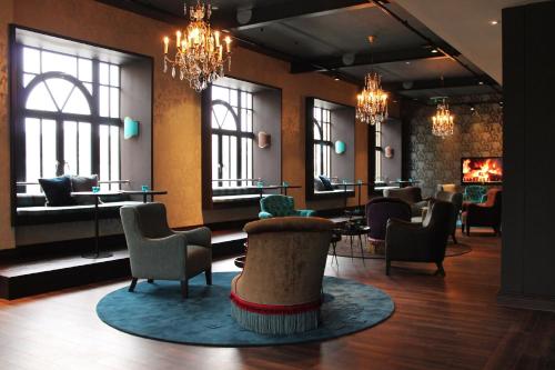 a lobby with chairs and tables and windows at Motel One Edinburgh-Princes in Edinburgh