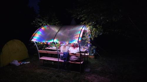 a group of people sitting in a tent at night at Glamping Fluffy Horns - Glempings Pūkainie Ragi in Plieņciems