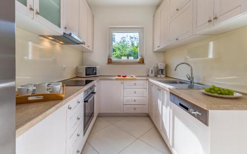 a kitchen with white cabinets and a sink at Lotus Villas Resort in Pula