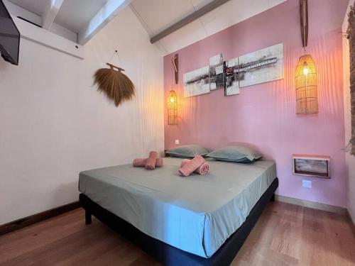 a bedroom with a large bed with pink walls at Ti Kaloo, 2ème ligne, 40 m du Lagon in Saint-Leu