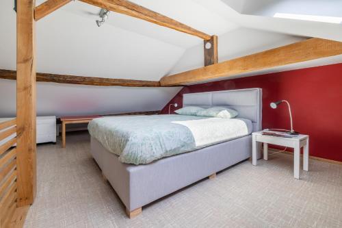 a bedroom with a bed and a red wall at Gîte Bed & Bedot in Fauvillers
