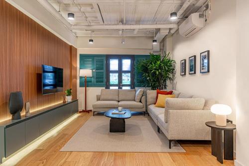 a living room with a couch and a tv at Weave Suites - Midtown in Singapore
