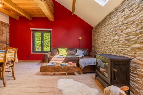 a living room with a couch and a stone wall at Gîte Bed & Bedot in Fauvillers
