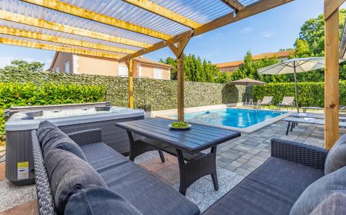 a patio with a table and chairs and a pool at Lotus Villas Resort in Pula