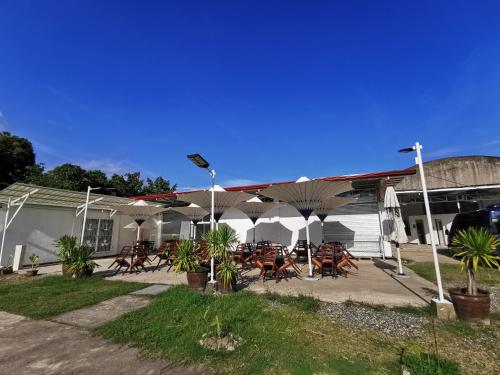 a patio with tables and chairs in front of a building at E&R Airport Hotel in Dumaguete