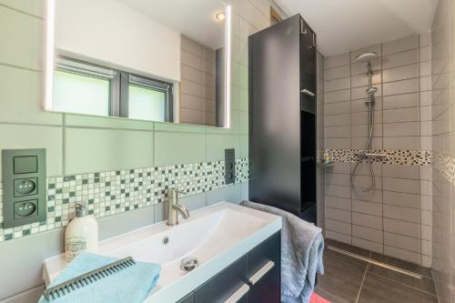 a bathroom with a tub and a sink and a mirror at Gîte Bed & Bedot in Fauvillers
