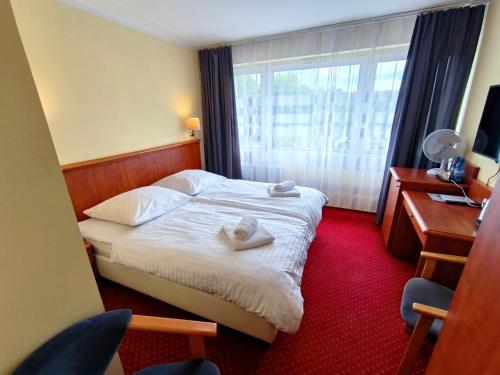 ein Hotelzimmer mit einem Bett mit Handtüchern darauf in der Unterkunft Arkadia in Kielce