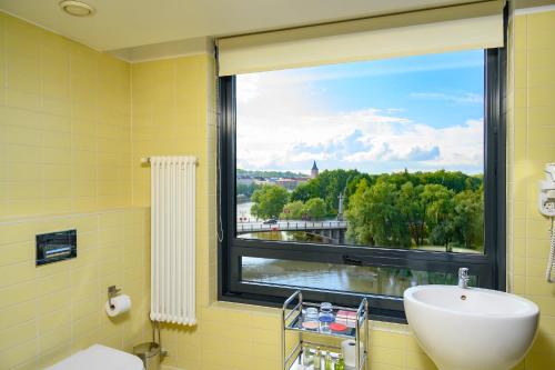 La salle de bains est pourvue d'un lavabo et d'une fenêtre avec vue. dans l'établissement Dorpat Hotel, à Tartu