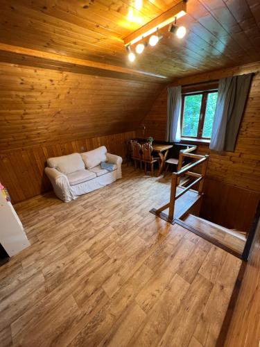 una habitación con sofá y mesa en una cabaña en Ludvíkova Chalupa, en Valašská Bystřice