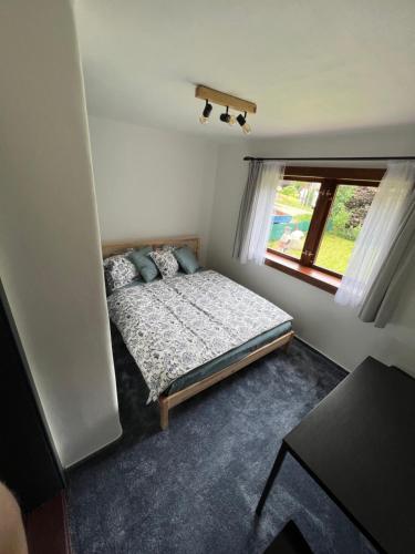 a small bedroom with a bed and a window at Ludvíkova Chalupa in Valašská Bystřice