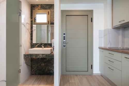 a bathroom with a door and a sink at Aetherion Studios & Suites in Kalyves Poligirou